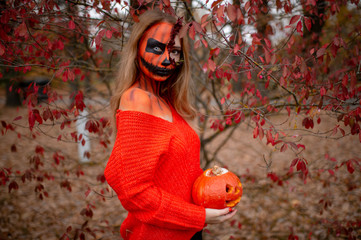 Young blonde girl with halloween face art posing outdoor.  Helloween celebration concept.