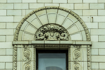 antique wooden frame with transparent glass on the facade of the building with a textured bas-relief