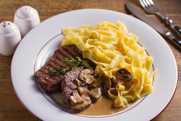 Beef steak and pasta with creamy mushroom sauce