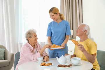 Obraz na płótnie Canvas Nurse assisting while elderly people having breakfast at retirement home