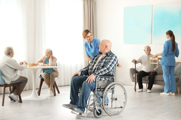 Nurses assisting elderly people at retirement home