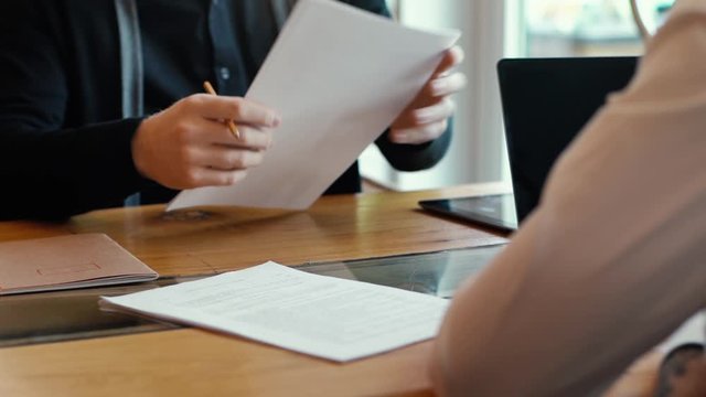Business partners sign contract in slow motion in interior of office room. Two ambitious business partners singing it at their table with laptop