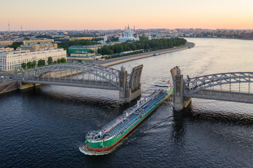 Naklejka premium Saint Petersburg. Russia. Bolsheokhtinsky bridge lifted. Bridge of Peter the Great at sunset. The drawbridges of Petersburg. Navigation on the Neva River. Cities of Russia. Panorama of St. Petersburg.