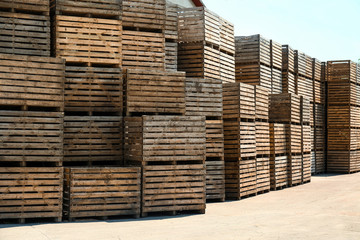 Pile of empty wooden crates outdoors on sunny day. Space for text