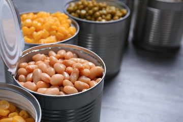Open tin cans of conserved vegetables, closeup. Space for text