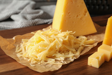 Grated and cut delicious cheese on board, closeup