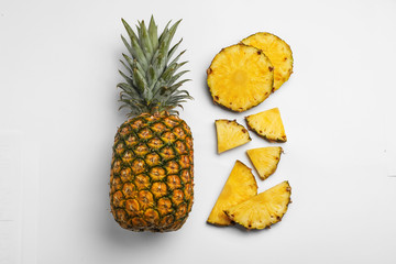 Composition with raw cut pineapples on white background, top view