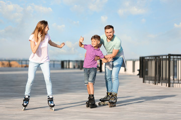 Obraz premium Happy family roller skating on city street