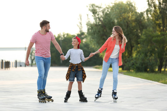 Happy family roller skating on city street
