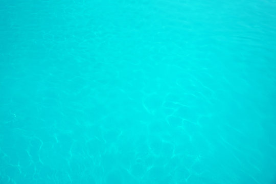 Surface of swimming pool with clean blue water as background