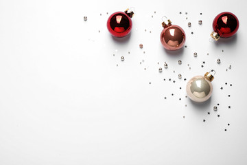 Colorful Christmas balls and sparkles on white background, top view. Space for text