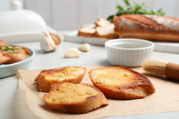 Slices of delicious toasted bread with garlic on table