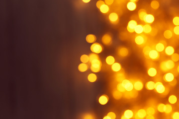 Blurred view of Christmas lights on dark background, space for text