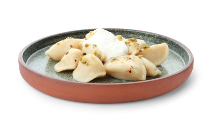 Delicious cooked dumplings with sour cream on white background