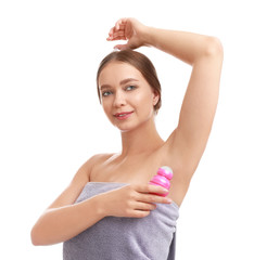 Young woman applying deodorant to armpit on white background