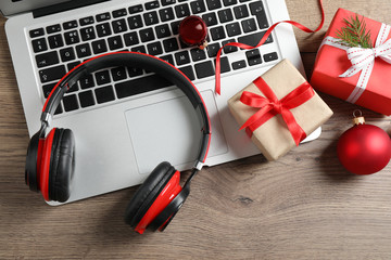 Flat lay composition with headphones on wooden background. Christmas music