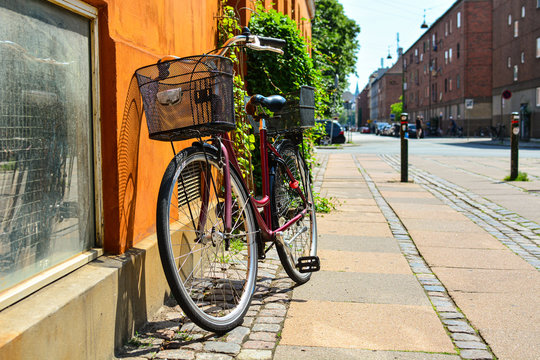 Bicycle with basket in front of the orange wall in Copenhagen, Denmark. Colorful old town architecture. Copenhagen style, European street, Denmark bicycle
