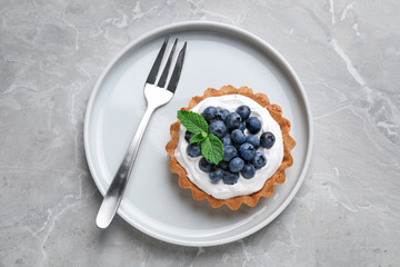 Tart with blueberries served on marble table, top view. Delicious pastries