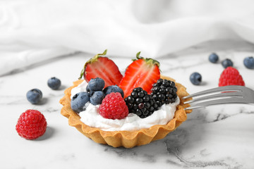 Tart with different berries on marble table. Delicious pastries
