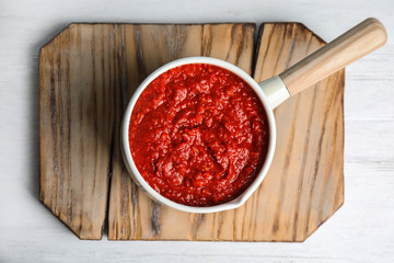 Delicious tomato sauce in pan on white wooden table, top view