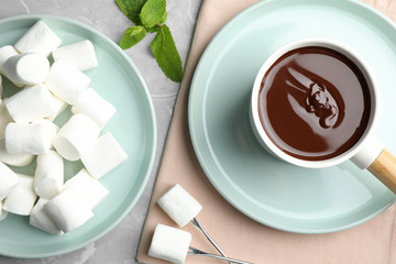 Fondue pot with dark chocolate and marshmallows on table, flat lay