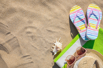 Flat lay composition with different beach accessories on sand. Space for text