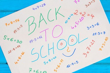 Creative idea depicting the return of children to school. White paper with mathematical operations and text back to school.