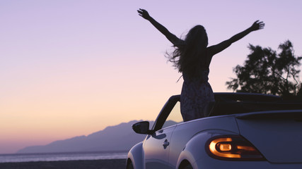 Young Woman in Cabriolet at Sunset - obrazy, fototapety, plakaty