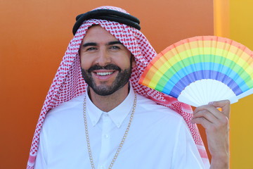 Attractive Arabic gay man holding a fan with the rainbow flag