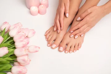 Outdoor kussens Het beeld van vrouwelijke benen en handen na pedicure en manicure. Benen zijn omgeven door roze tulpen en kaarsen. © forma82
