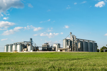 silver silos on agro manufacturing plant for processing drying cleaning and storage of agricultural products, flour, cereals and grain. Granary elevator © hiv360