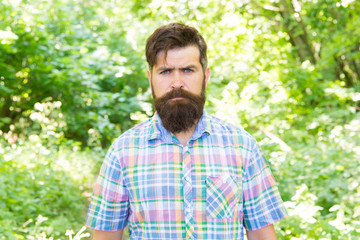 Naklejka na ściany i meble Brutal style trends. Bearded man with brutal look on natural landscape. Caucasian guy with long brutal beard and mustache on summer nature. Brutal hipster wearing casual style outdoor