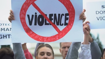 Crowd with posters chanting Stop violence slogans, domestic abuse, human rights
