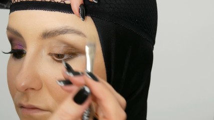 Professional stylist make-up artist makes eye makeup model. Face model with evening make-up close up view