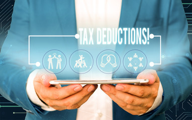 Text sign showing Tax Deductions. Business photo text reduction income that is able to be taxed of expenses Male human wear formal work suit presenting presentation using smart device