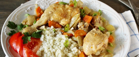 keto dish. Chicken with Cauliflower Rice. low carbohydrates a lot of protein. stewed chicken with celery and carrots in a white plate.