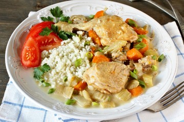 keto dish. Chicken with Cauliflower Rice. low carbohydrates a lot of protein. stewed chicken with celery and carrots in a white plate.