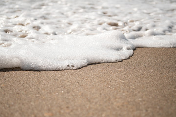 Close-up of Foamy Water Rolling into Shore
