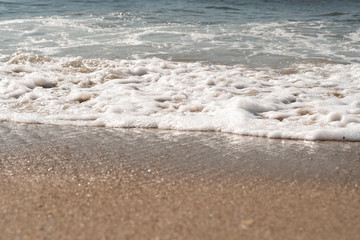 Close-up of Foamy Water Rolling into Shore