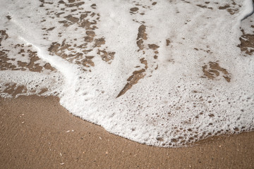 Close-up of Foamy Water Rolling into Shore