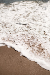 Foamy Water Rolling onto Shore