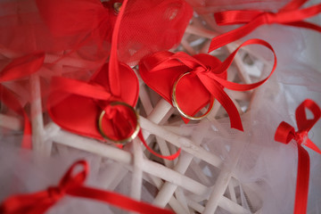 fedi per sposi su fiocchi rossi e bianchi oro