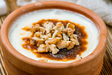 sutlac with nuts on wooden table. Turkish cuisine.