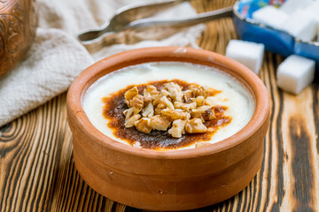 sutlac with nuts on wooden table. Turkish cuisine.