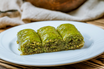 Sarma with pistachios on wooden table. Turkish cuisine.