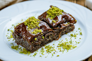 chocolate baklava with pistachios on wooden table. Turkish cuisine