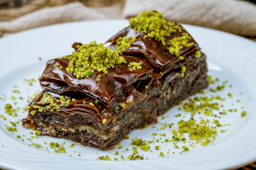 chocolate baklava with pistachios on wooden table. Turkish cuisine