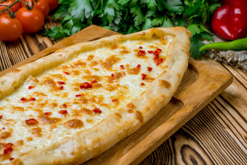 Turkish pide with cheese on wooden background