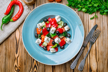 Greek salad with feta and vegetables on wooden table
