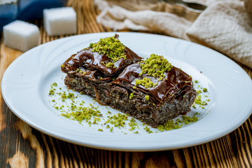 chocolate baklava with pistachios on wooden table. Turkish cuisine